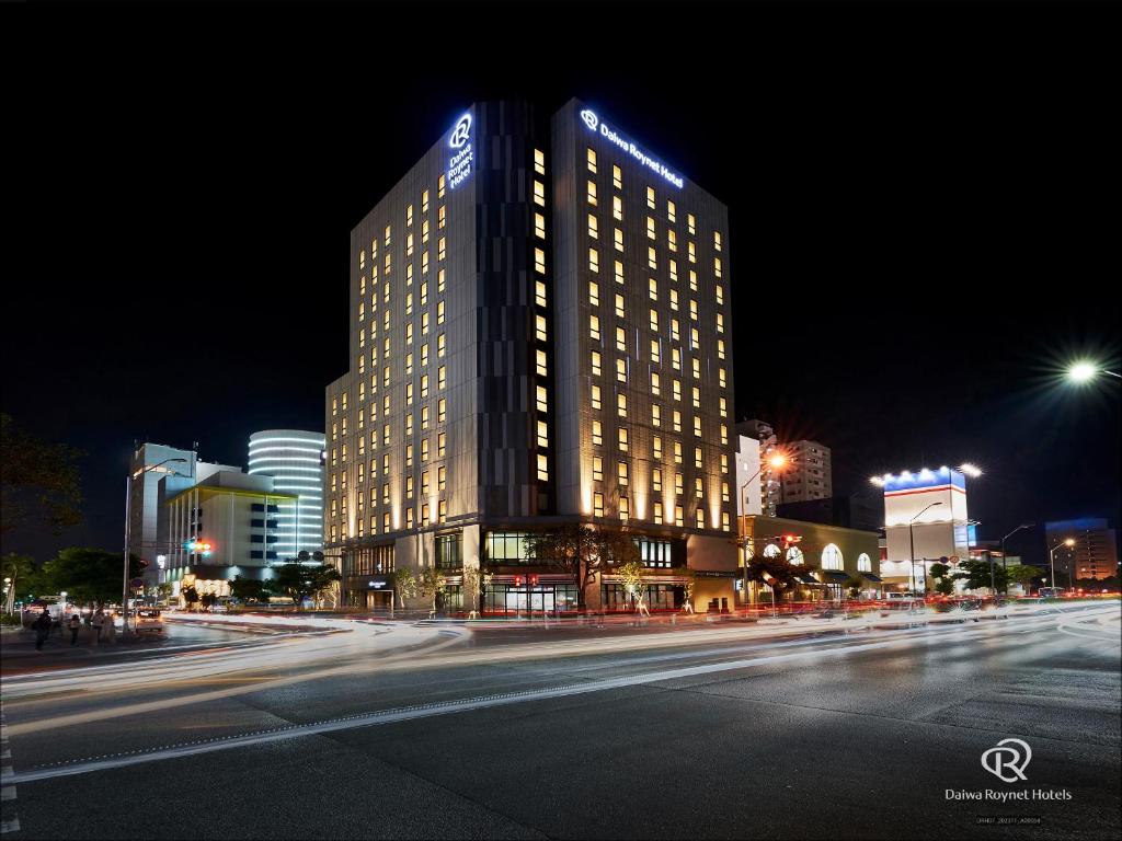 een verlicht gebouw in een stadsstraat 's nachts bij Daiwa Roynet Hotel NAHA-OMOROMACHI PREMIER in Naha