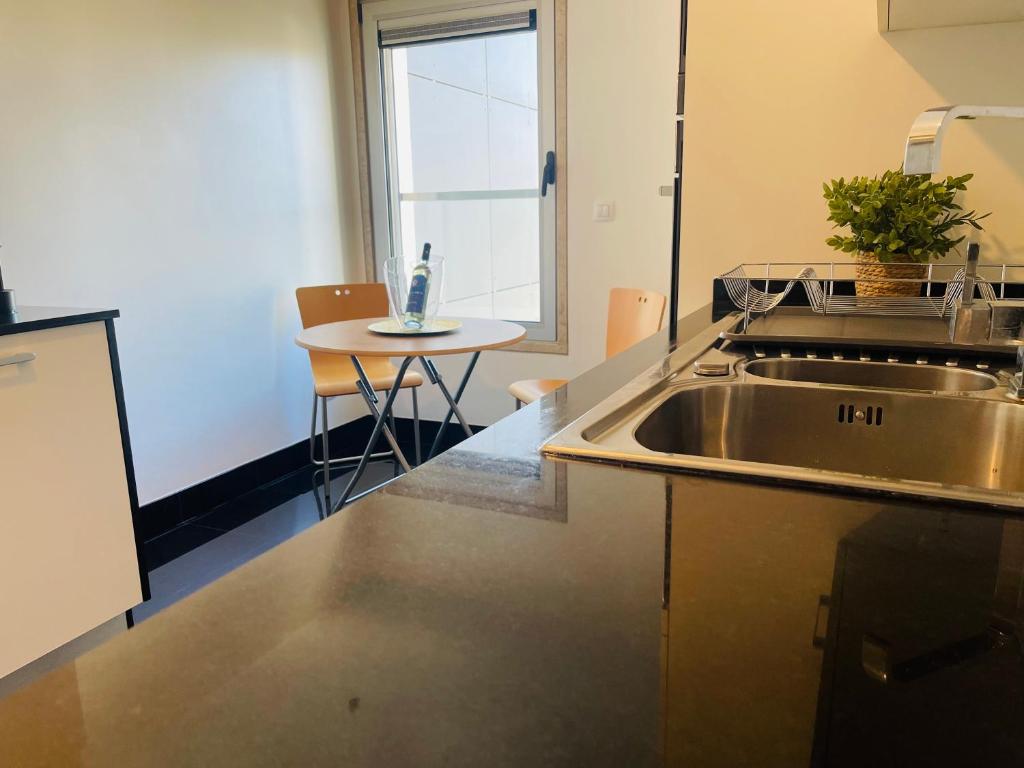 a kitchen with a stainless steel sink and a table at Expo Luxury apartment in Lisbon