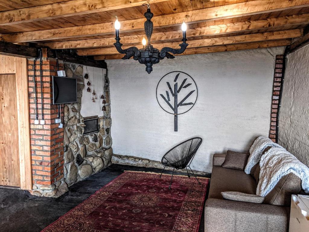 ein Wohnzimmer mit einem Sofa und einem Baum an der Wand in der Unterkunft Vasanna in Kossiw