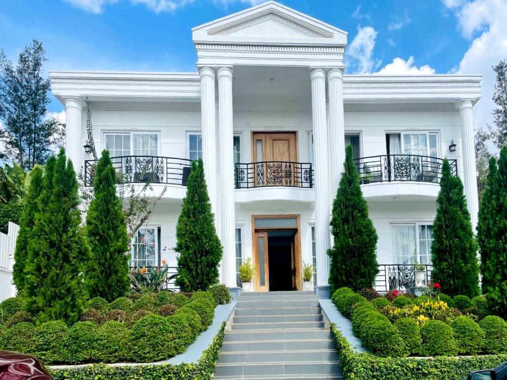 a white house with a staircase in front at White villa apartment in Kigali