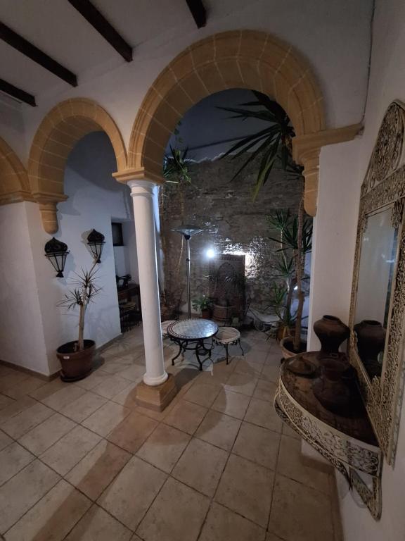 ein großes Wohnzimmer mit einem Tisch und einem Kamin in der Unterkunft Hostal Fenix in Jerez de la Frontera
