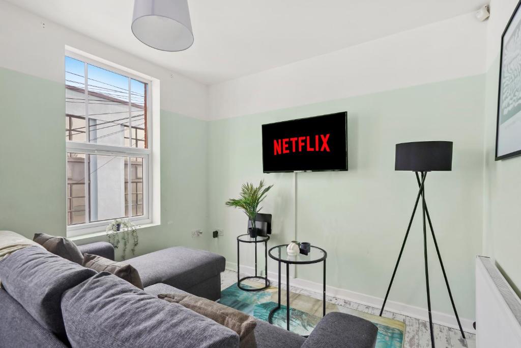a living room with a couch and a tv on the wall at Boutique Apartments in Central Bristol in Bristol