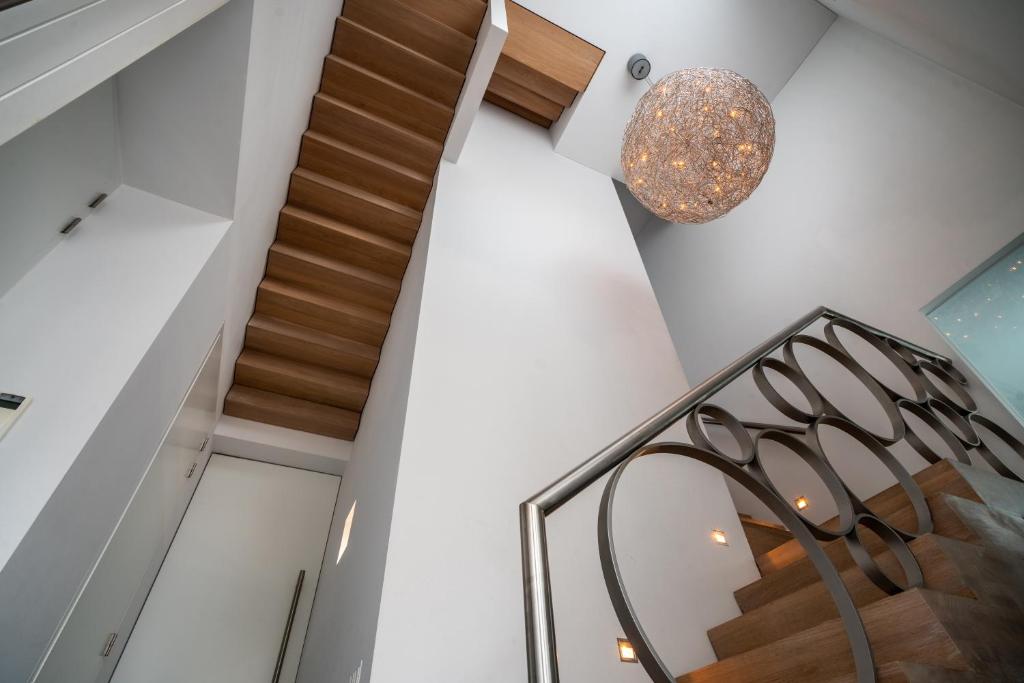 a spiral staircase in a house with a chandelier at Bed & Wellness Boxtel, luxe kamer met airco en eigen badkamer in Boxtel