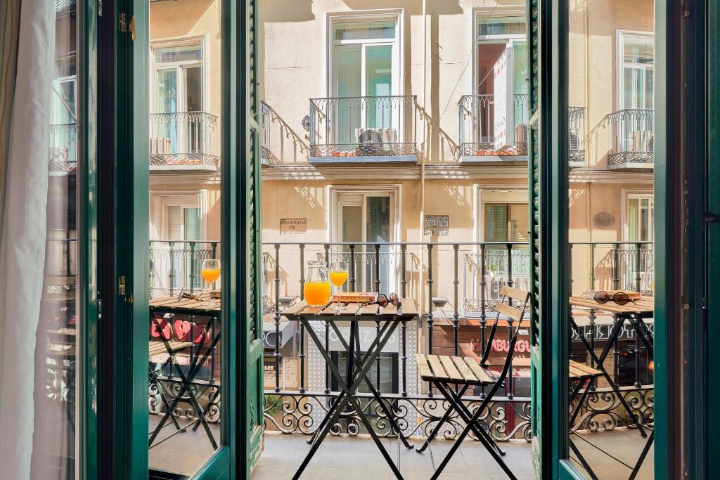 a balcony with a table with two glasses on it at Blume Cruz Suites in Madrid