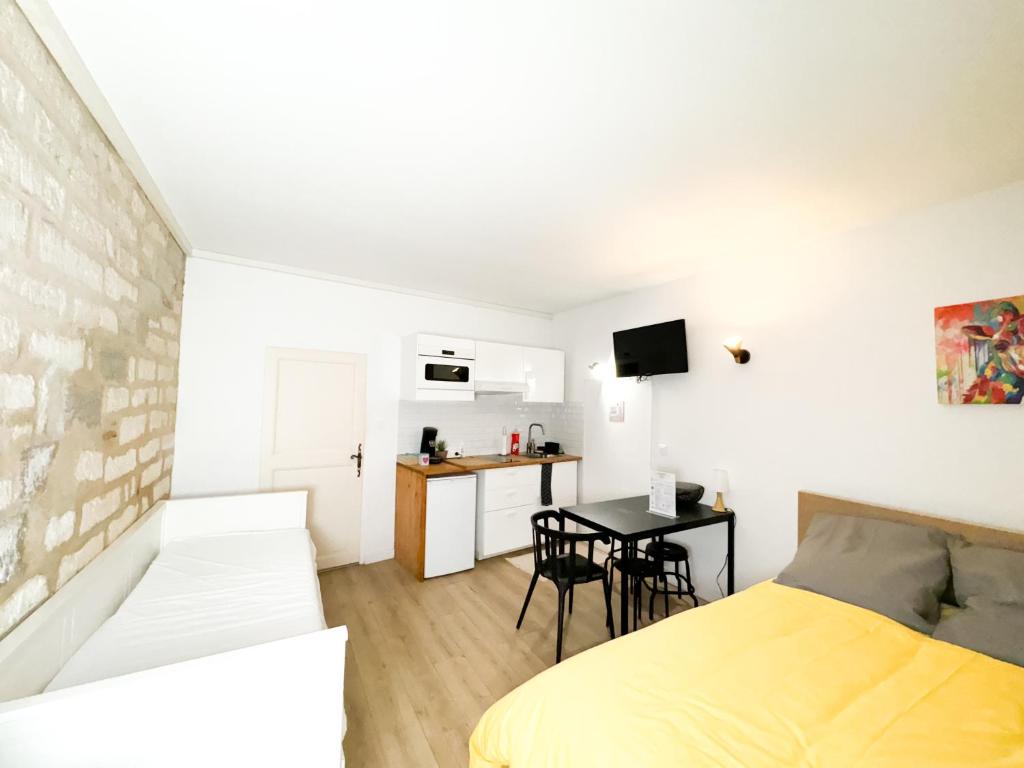 une chambre avec un lit et une table et une cuisine dans l'établissement Balisier Studio avenue de Lodève, à Montpellier