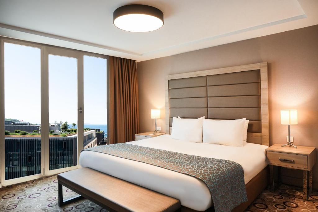 a hotel room with a large bed and windows at Nidya Hotel Galataport in Istanbul