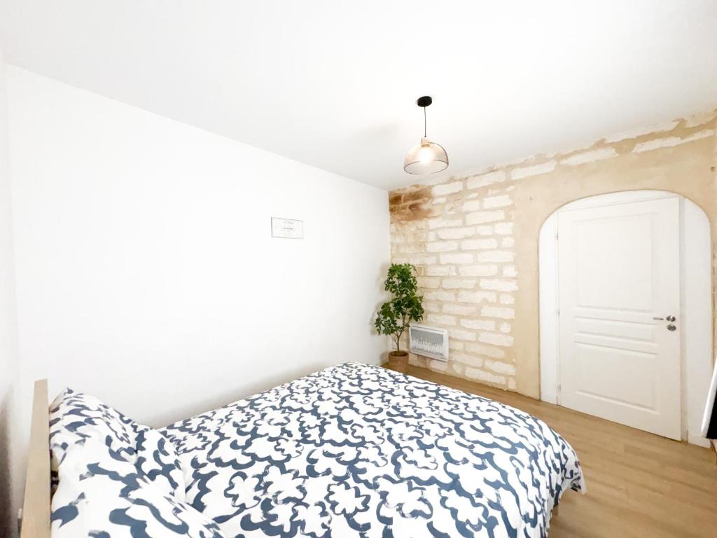 um quarto com uma cama e uma parede de tijolos em Bégonias Appartement T3 Avenue de Lodève em Montpellier