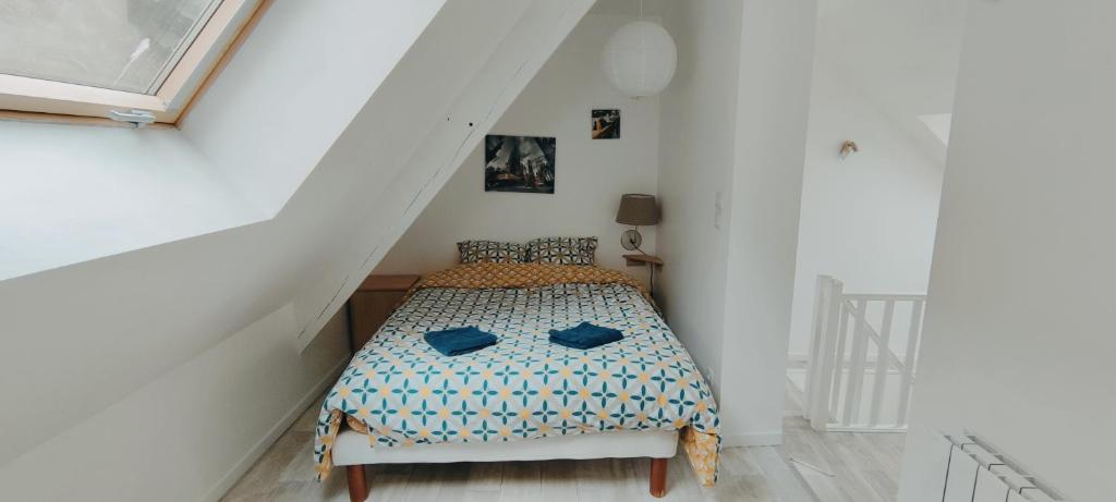 a bedroom with a bed in a white room at Double gite, Duplex et Chaleureuse petite maison in Beaumont-sur-Sarthe