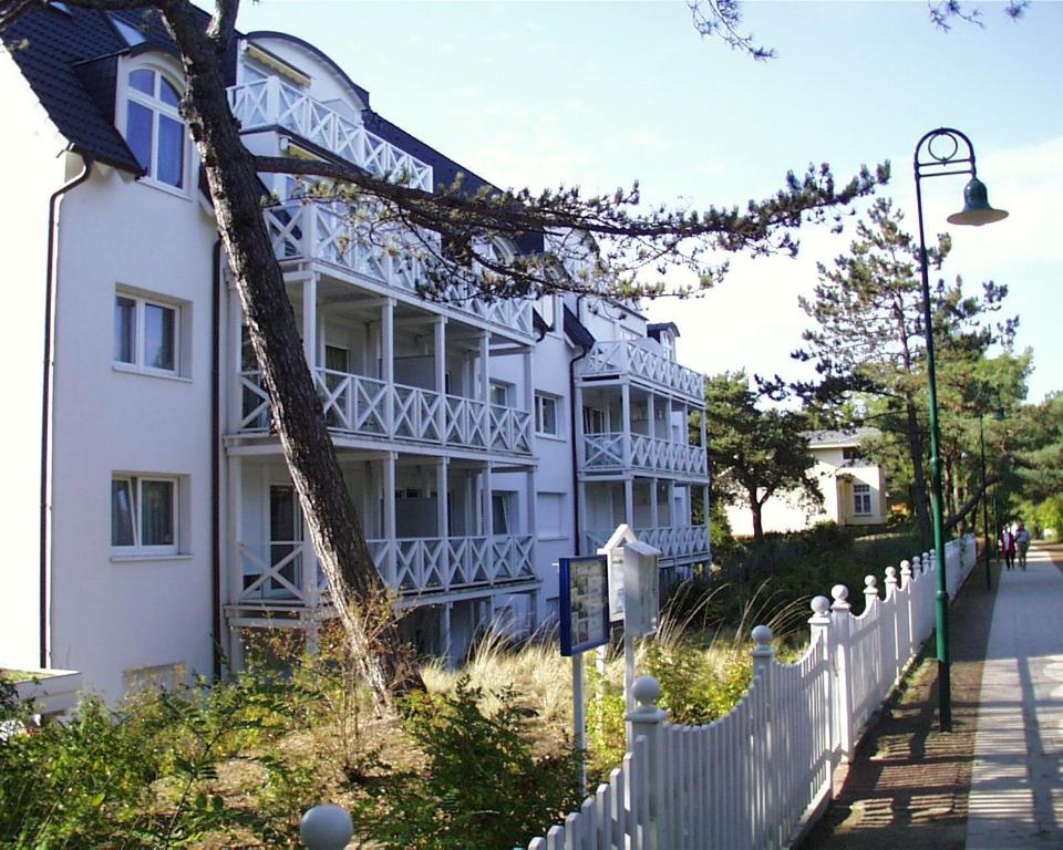 een wit gebouw met een wit hek ernaast bij Dünenhaus Christa - Wohnung 10 - strandnah in Bansin