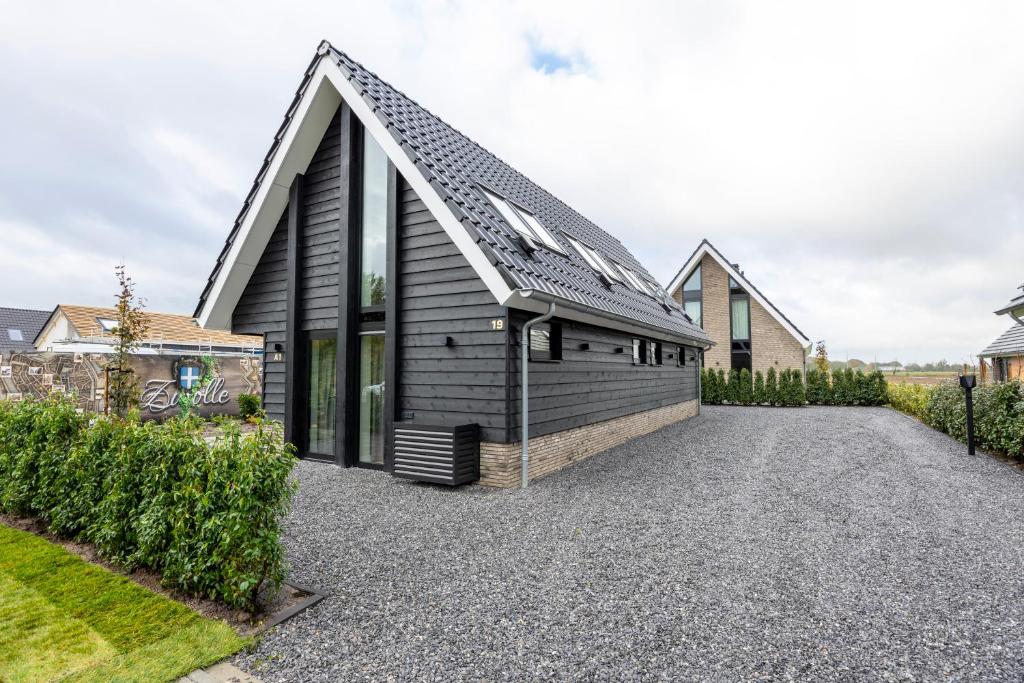 une maison avec un toit en pente sur une allée de gravier dans l'établissement Bed & Breakfast Ons Plekje, à Zwolle