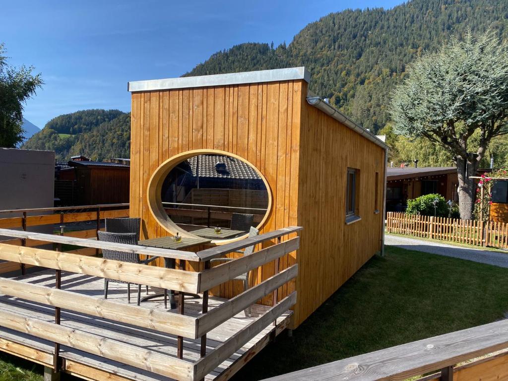 un bâtiment en bois avec une fenêtre circulaire sur une cour dans l'établissement Unique Tiny Eco Lodges with gorgeous views to Jungfrau Massiv, à Interlaken
