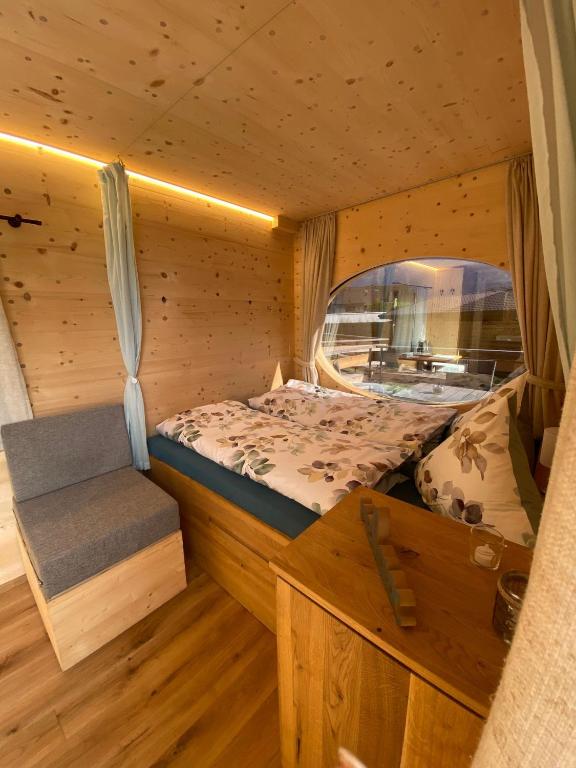 インターラーケンにあるUnique Tiny Eco Lodges with gorgeous views to Jungfrau Massivのログキャビン内のベッドルーム(ベッド1台、ベンチ付)