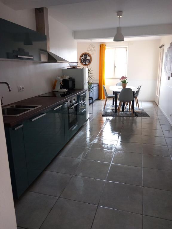 ラ・ロック・ガジャックにあるle petit bambouのテーブルとダイニングルームのあるキッチン