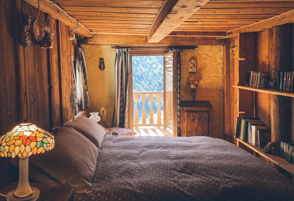 a bedroom with a large bed and a window at La Taverna dei Due Gufi in Saint-Rhémy-en-bosses