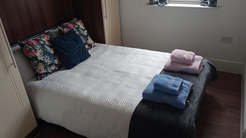 a bed with two towels sitting on top of it at Notting Hill Next Door Bedroom in the share flat in London