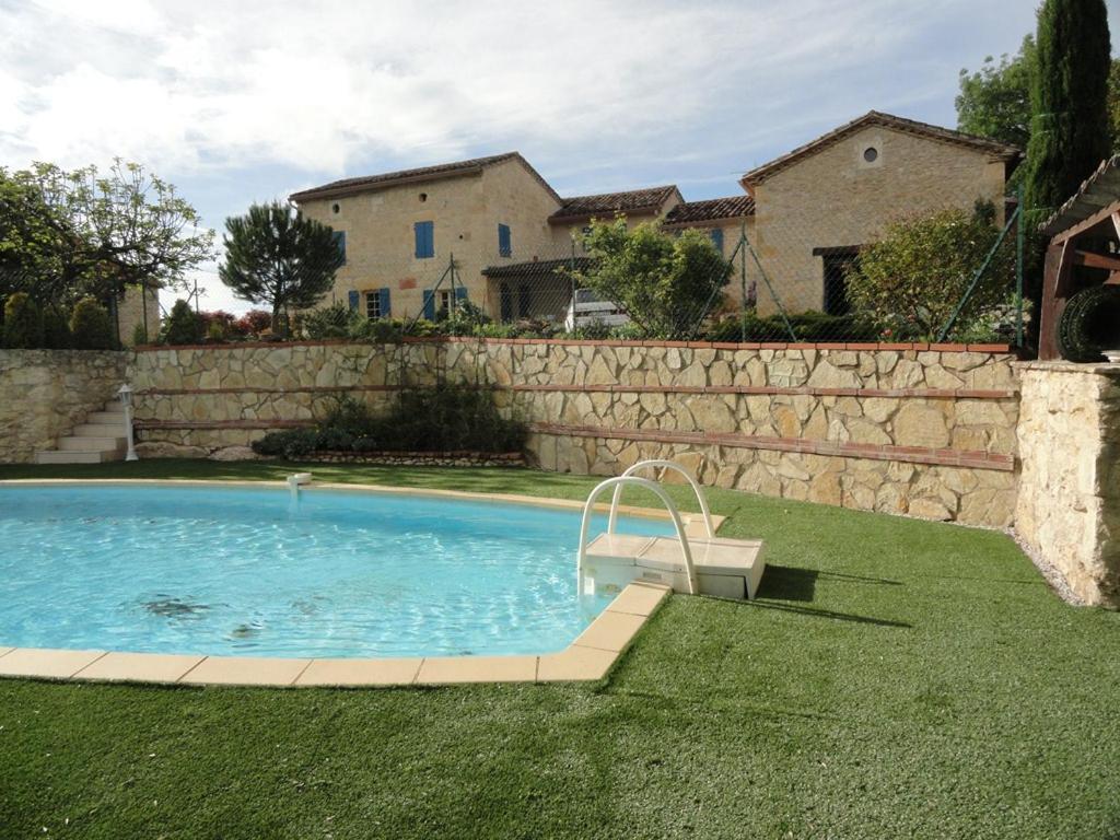 una piscina en un patio junto a una pared de piedra en Calme et bien-être, en Cestayrols