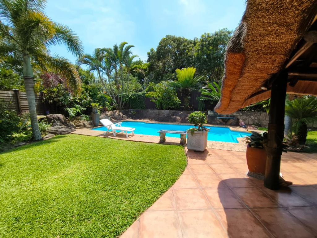 a backyard with a swimming pool and grass at Sea La Vie in Richards Bay