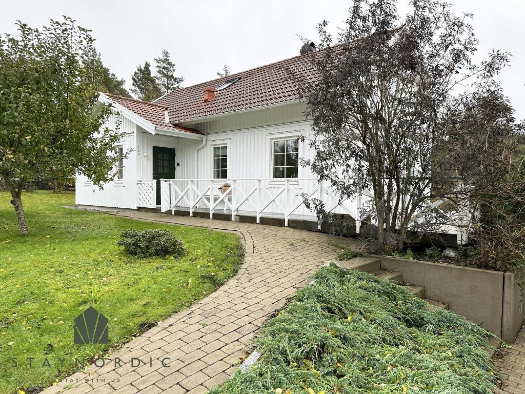 une maison blanche avec une passerelle devant elle dans l'établissement Modern and cozy cottage near beautiful Fjallbacka, à Fjällbacka