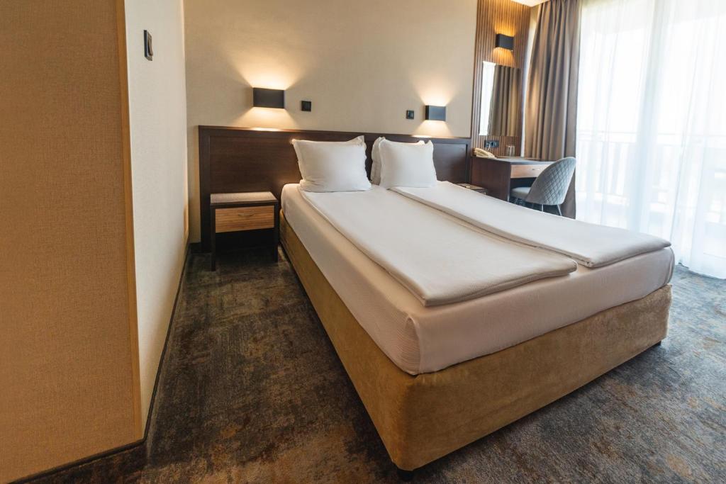 Postel nebo postele na pokoji v ubytování Kalithea Family Hotel