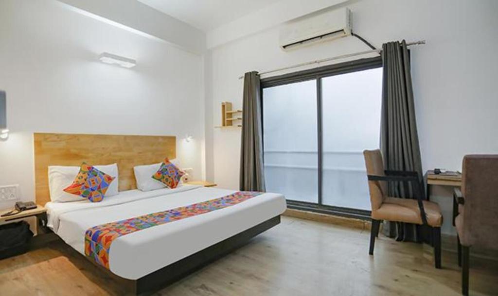 a bedroom with a bed and a desk and a window at FabHotel F9 Sector 51 in Noida