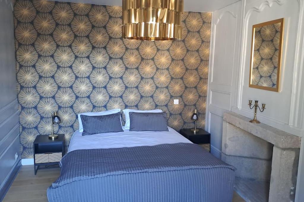 ein Schlafzimmer mit einem blauen Bett und einer Wand in der Unterkunft Chez germaine in Murat