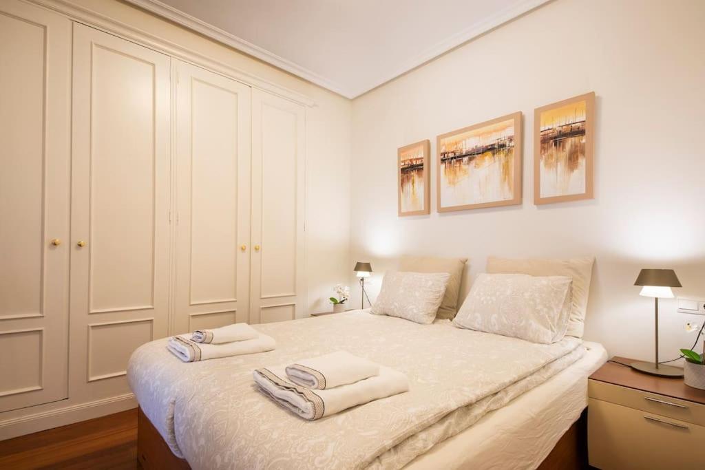 1 dormitorio con 1 cama con 2 toallas en APARTAMENTO EN EL CORAZÓN DE LA CIUDAD con PARKING PRIVADO, en San Sebastián