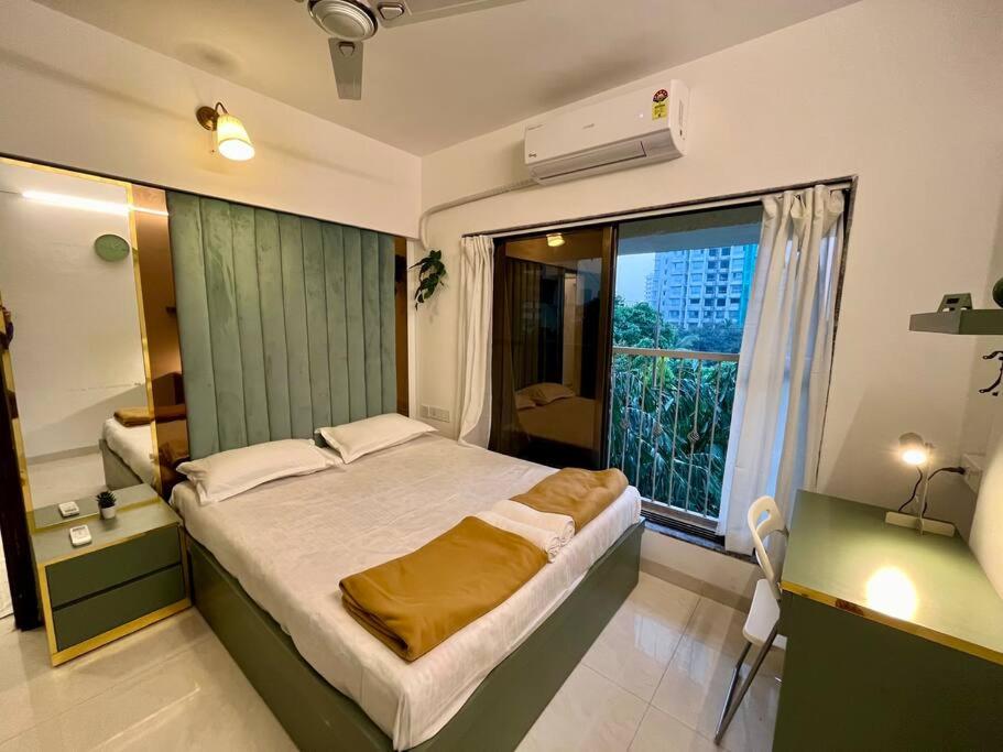 La Olive 1 BHK Service Apartment في مومباي: غرفة نوم بسرير كبير ونافذة كبيرة