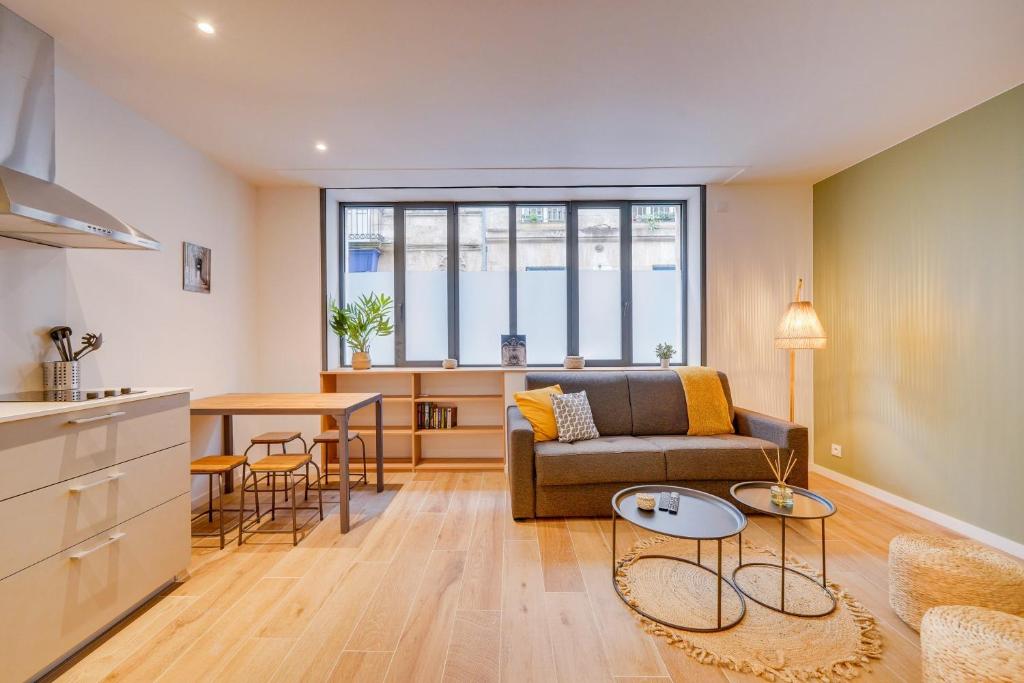 un salon avec un canapé et une table dans l'établissement Les Capucines - Bel appt en centre-ville, à Bordeaux