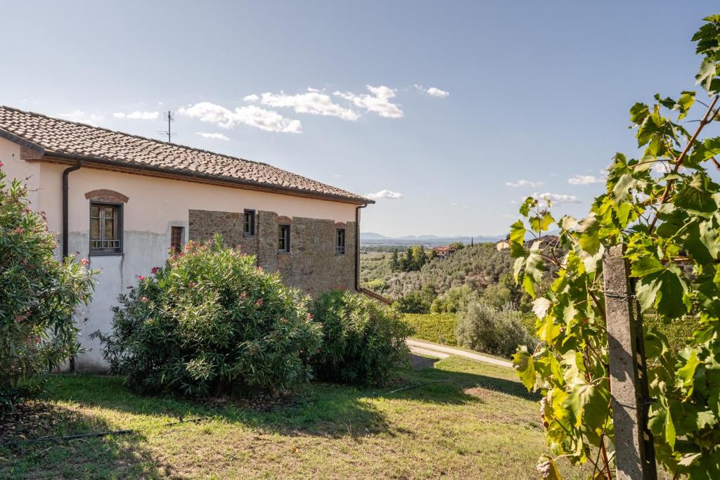 une vue extérieure sur une maison avec des montagnes en arrière-plan dans l'établissement Agriturismo Fadanelli - La Cantina, à Lamporecchio