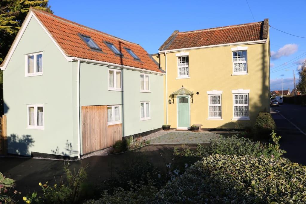 a white and yellow house with a brown roof at The Old Wagon & Horses 19th Century Beer House in Glastonbury