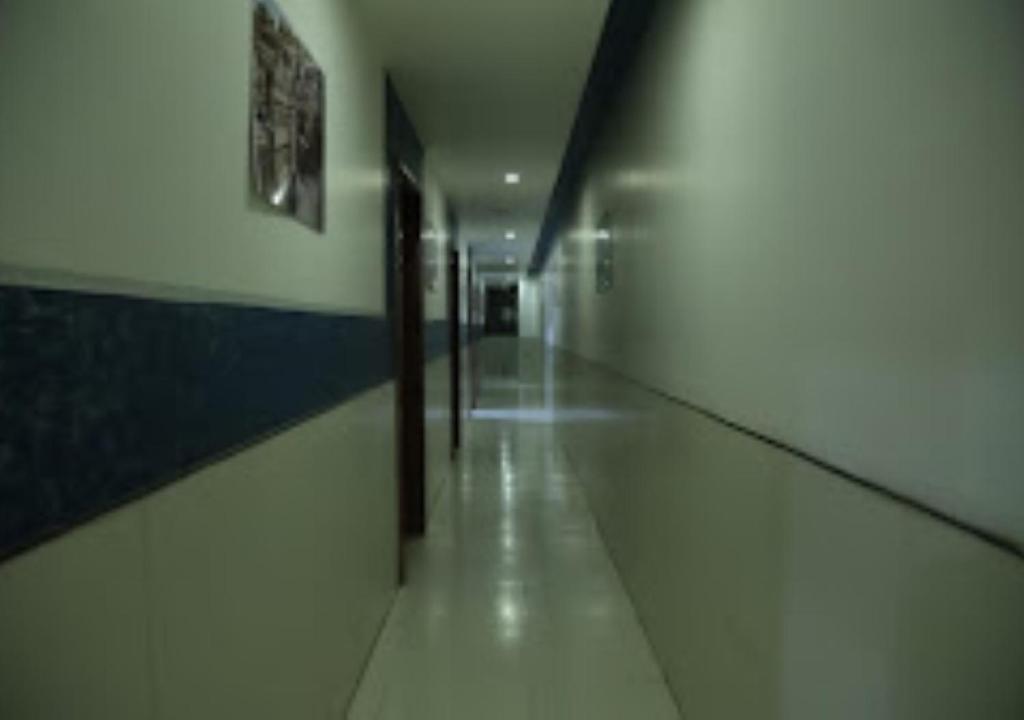 a hallway in a building with a long corridor at Hotel Kewal INN Jalgaon in Jālgaon