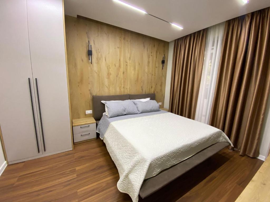 um quarto com uma cama e piso em madeira em Arkle Apartment 6 em Tirana