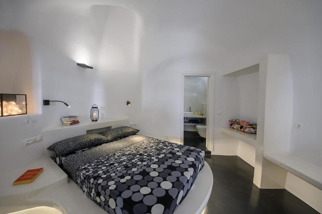 a bedroom with a black and white bed in a room at Santorini traditional 1Bd apt with private hot tub in Fira