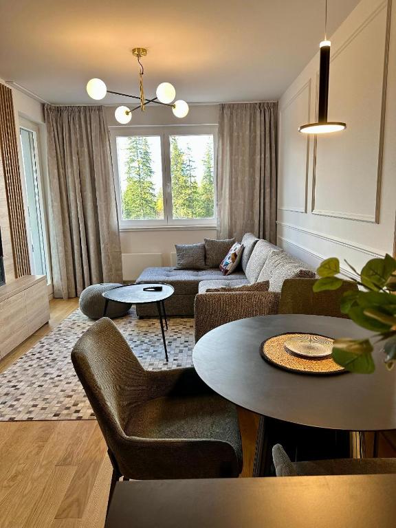 a living room with a couch and a table at Massimo Apartment Jahorina Snježna dolina in Jahorina