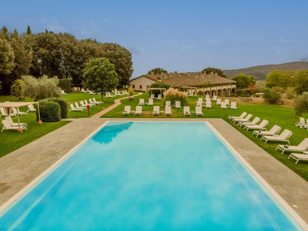 a swimming pool with lounge chairs and a resort at Tenuta di Artimino member of Meliá Collection in Artimino