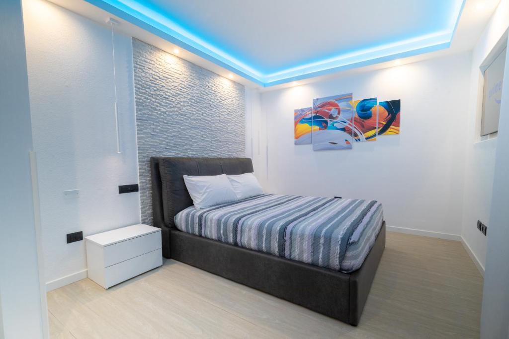 a small bedroom with a bed and a blue ceiling at Blue Island - Luxury House in Olbia