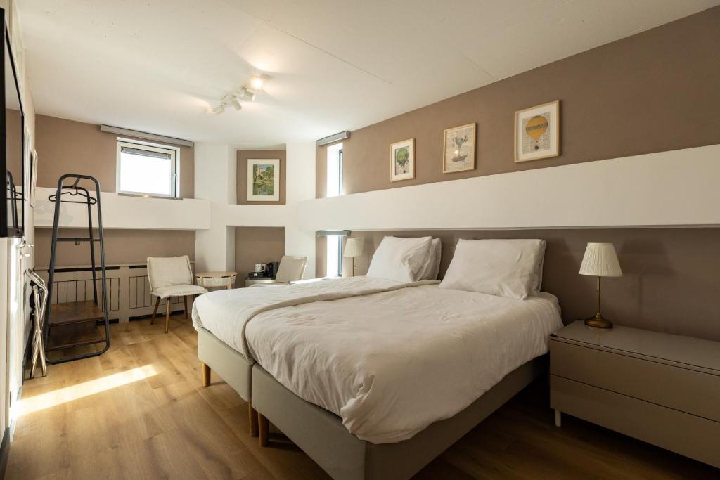 a bedroom with a large bed and a desk at B&B De Tulpentoren in Roelofarendsveen