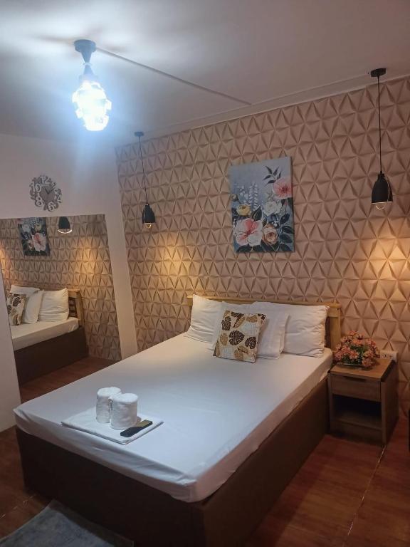 1 dormitorio con 1 cama grande con sábanas blancas en DJCI APARTELLE, en Cabanatúan