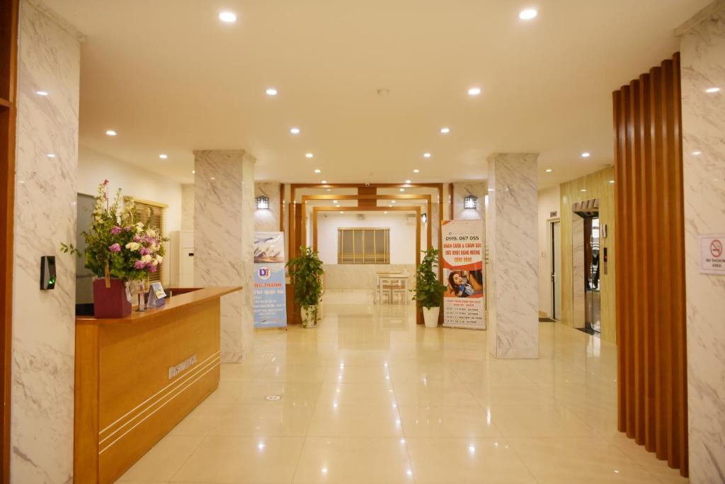 eine Lobby eines Gebäudes mit Blumen auf dem Tresen in der Unterkunft GEM Apartment & Hotel in An Khê