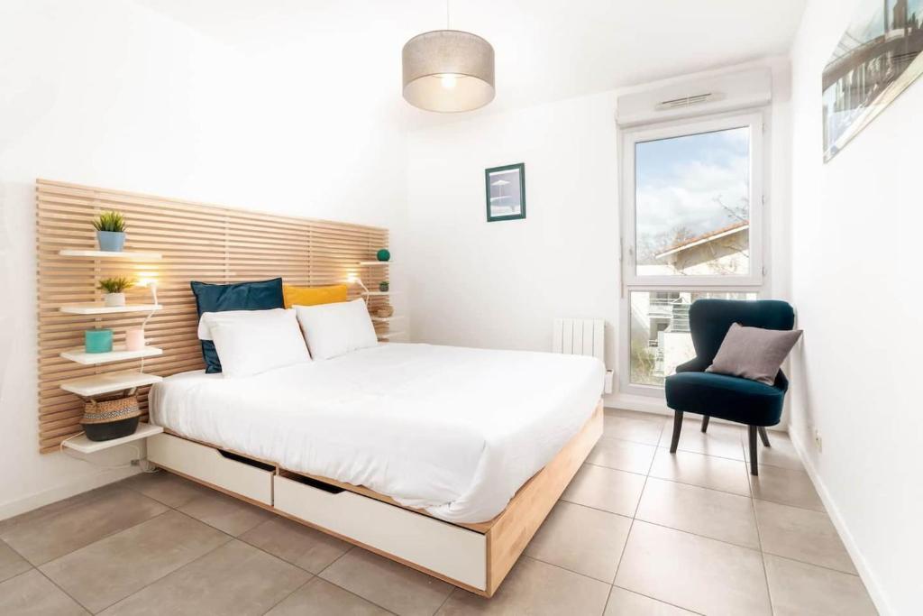 um quarto com uma cama, uma cadeira e uma janela em Apt moderne & Confortable - Parking free em Toulouse