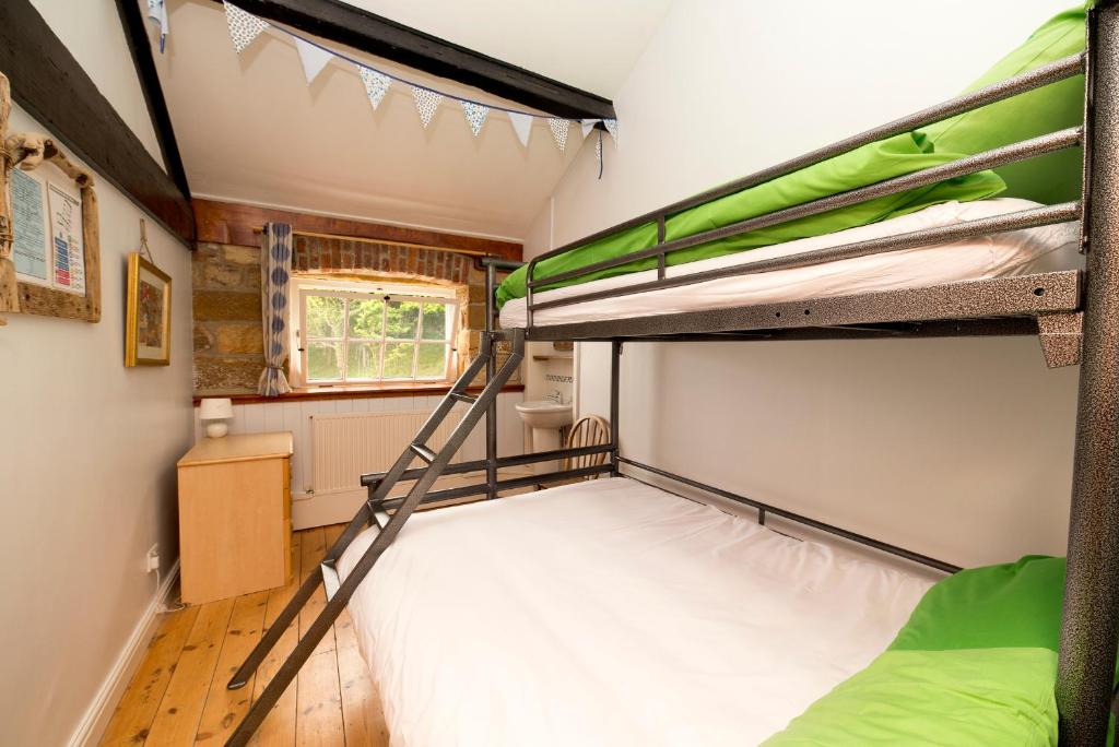Pokój z 2 łóżkami piętrowymi i oknem w obiekcie YHA Boggle Hole w mieście Fylingthorpe