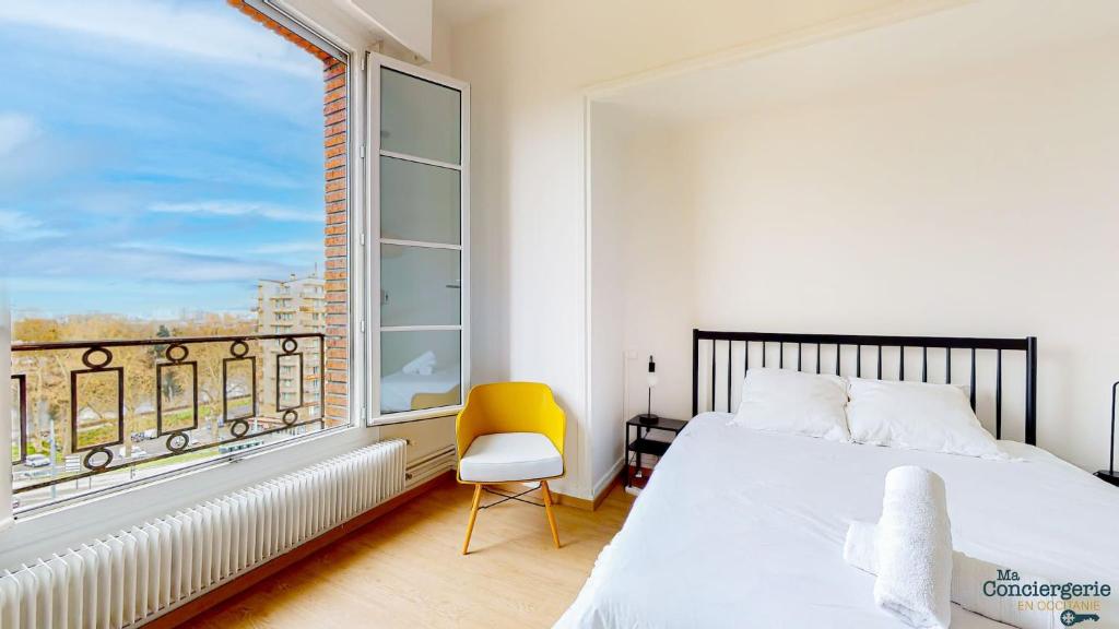 1 dormitorio con cama y ventana con silla amarilla en Fac 6 - Vue Garonne - Tram - Parking, en Toulouse