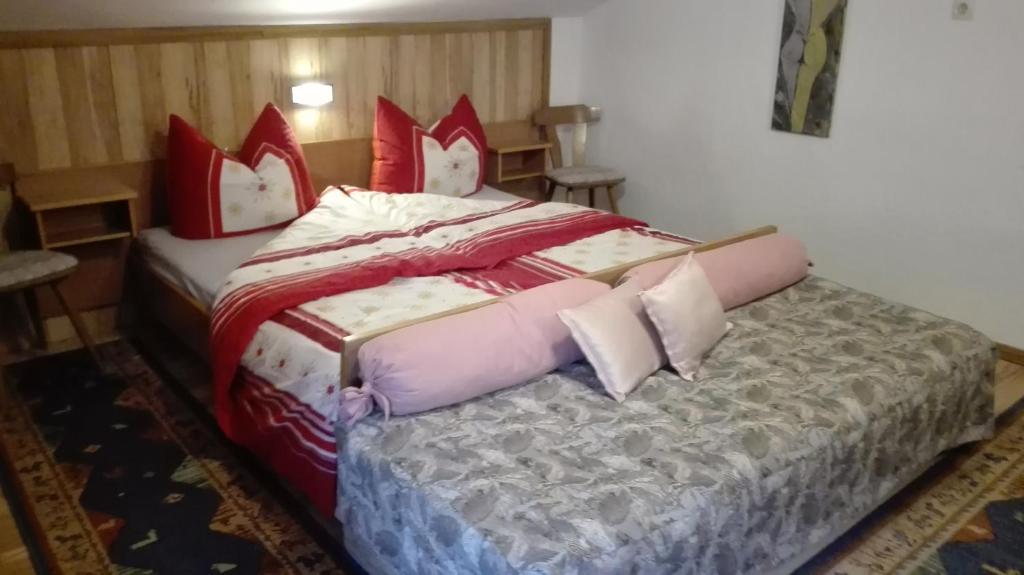 a bedroom with a large bed with red and white pillows at Haus Agerer FEWO 2. Stock in Tarrenz