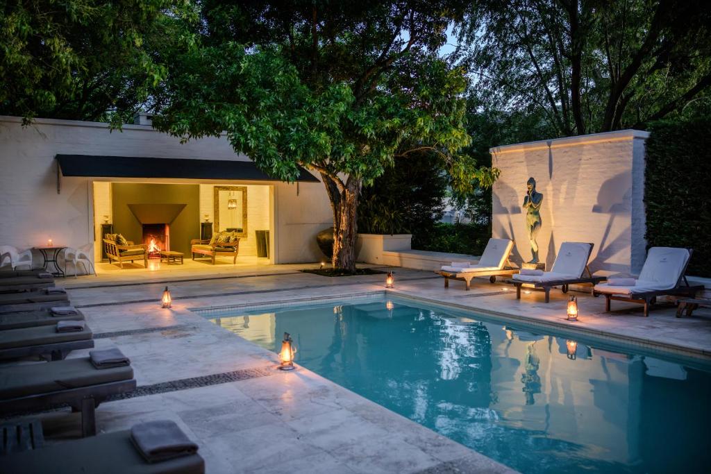 - une piscine avec des chaises longues et une cheminée dans l'établissement Grande Provence, à Franschhoek