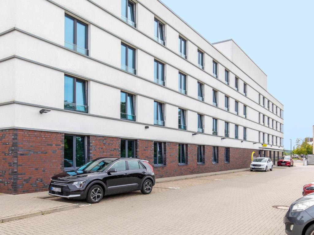 ein schwarzes Auto, das vor einem Gebäude parkt in der Unterkunft B&B Hotel Lüneburg in Lüneburg