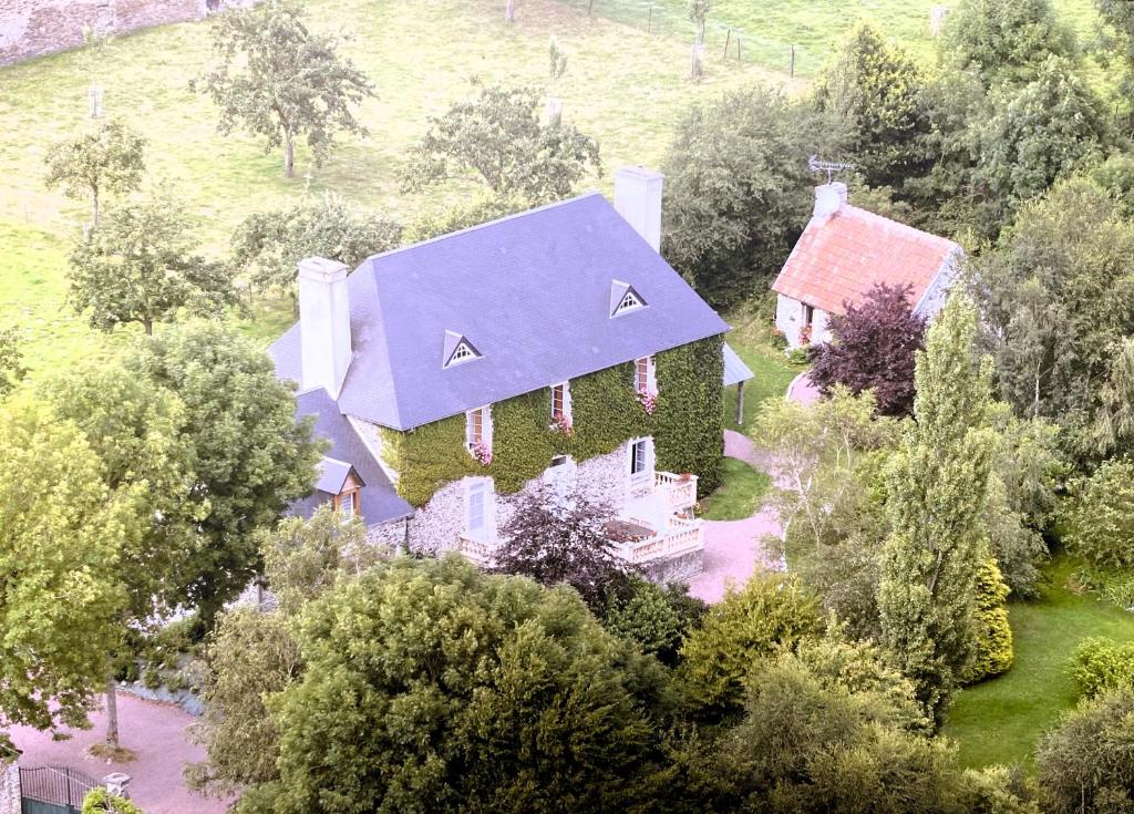 uma vista geral de uma casa com uma cobertura de hera em Le Pont de Benneville em Cahagnes