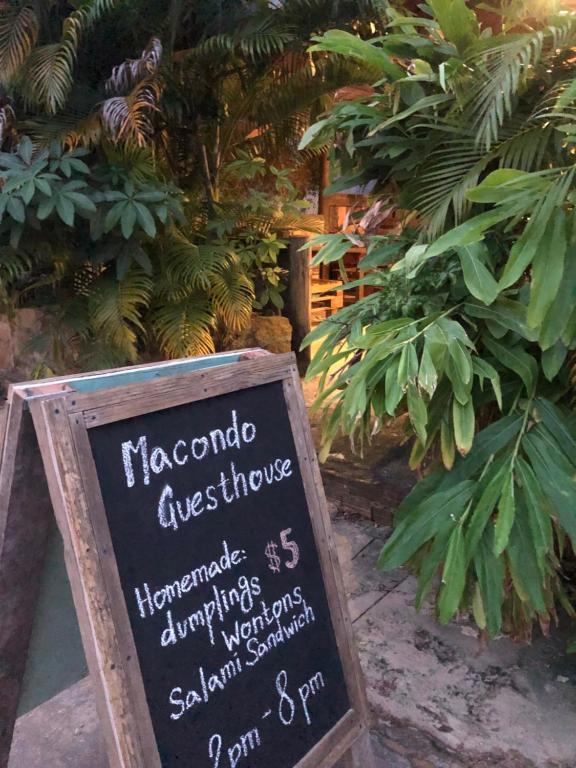 una pizarra con un cartel frente a un jardín en Macondo en Koh Rong Sanloem