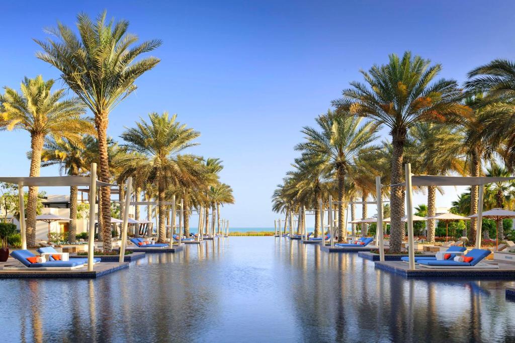 une rangée de palmiers et de bateaux sur une étendue d'eau dans l'établissement Park Hyatt Abu Dhabi Hotel and Villas, à Abu Dhabi