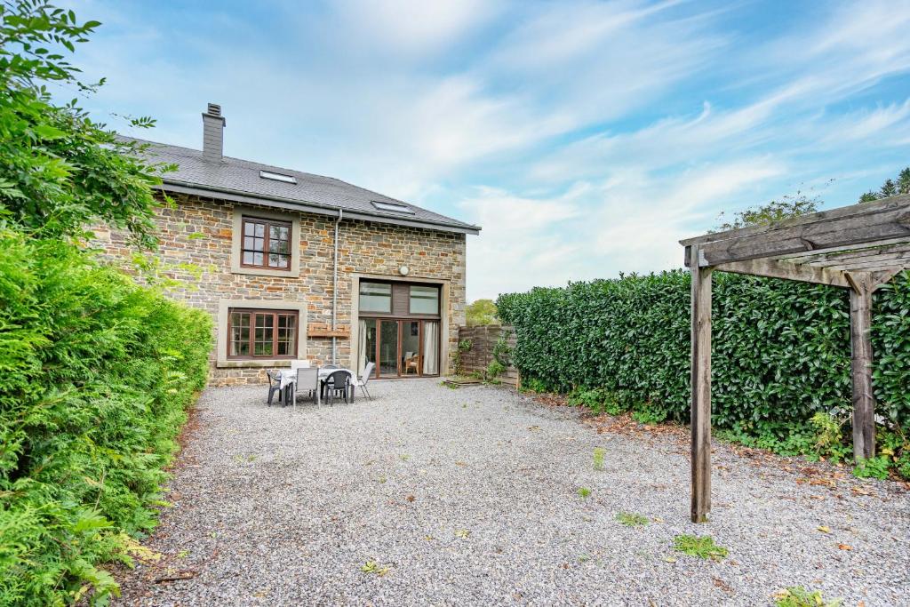 an external view of a brick house with a patio at Le jardin du vieux moulin 6A in Rendeux
