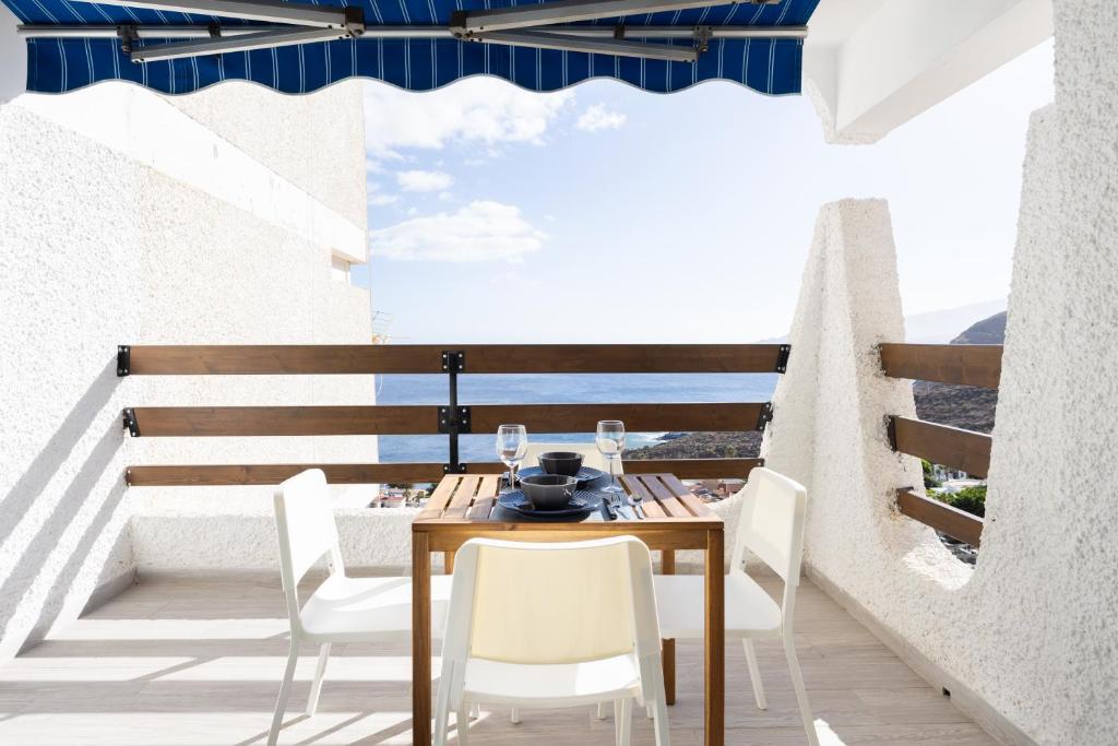 d'une table et de chaises sur un balcon avec vue sur l'océan. dans l'établissement Home2Book Bright Studio Ocean View Tabaiba, à Tabaiba